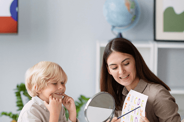 A teacher helping a child practise speaking